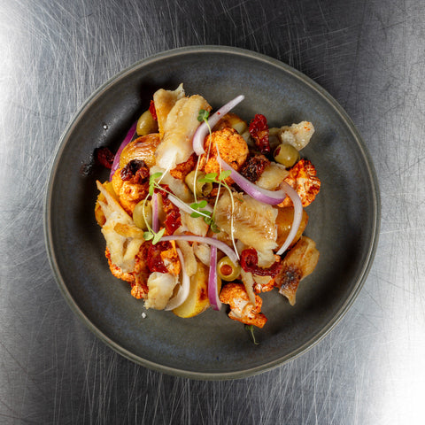 Salada de bacalhau com batata, couve-flor defumada, azeitona e ovo de codorniz